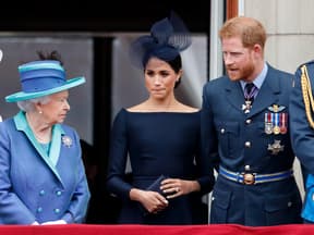 Die Queen, Meghan und Harry stehen ernst nebeneinander