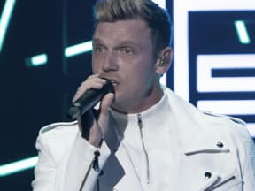 Nick Carter guckt ernst mit Mikrofon in der Hand