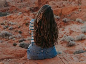 Frau mit langen Haaren in den Bergen