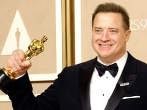 Brendan Fraser lächelt mit seiner Auszeichnung. 