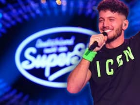 Momo Chahine mit Mikrofon in der Hand vor DSDS-Logo