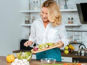 Frau in den Wechseljahren kocht