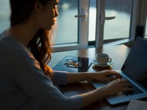 Frau im dunkeln konzentriert am Laptop