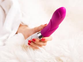 Frau hält Sextoy in der Hand