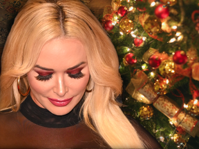 Daniela Katzenberger schaut zu Boden - im Hintergrund ein geschmückter Weihnachtsbaum 