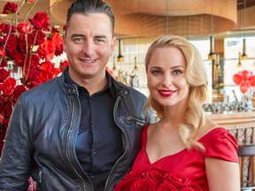 Andreas Gabalier und Silvia Schneider mit einem Strauß roter Rosen