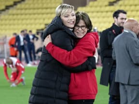 Fürstin Charlène und Prinzessin Stéphanie umarmen sich bei einem Fußballspiel. 