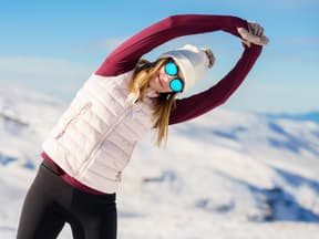 frau macht dehnübungen im schnee