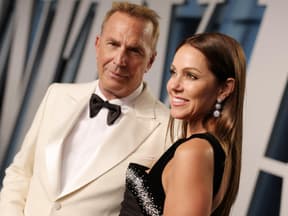 Kevin Costner wirkt verhalten, Christine Baumgartner lächelt. glücklich