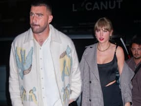 Travis Kelce und Taylor Swift halten sich an der Hand mit angespannten Gesichtsausdrücken