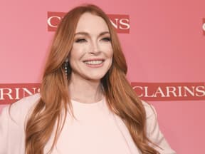 Lindsay Lohan strahlt vor pinkem Hintergrund