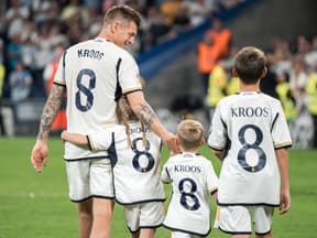 Toni Kroos mit seinen drei Kindern auf dem Platz von hinten