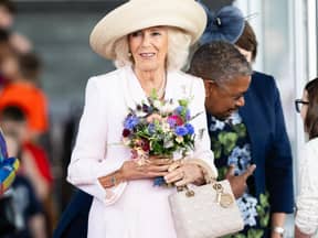 Königin Camilla mit Blumen und einer Lady Dior Bag