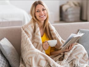 Frau mit Decke auf Sofa