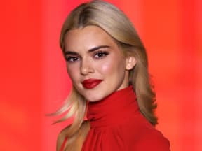 kendall jenner mit blonden haaren vor rotem hintergrund