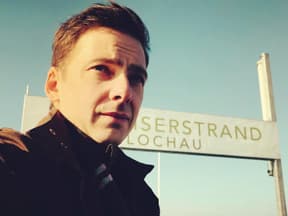 Stefan Pohl macht vor einem Schild ein Selfie