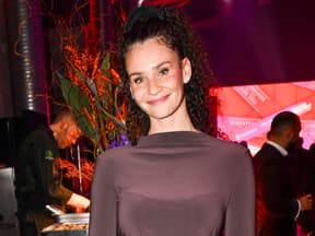 Betty Taube lächelt vor Blumen-Bouquet