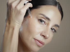 Frau mit Anti-Aging-Serum-Pipette