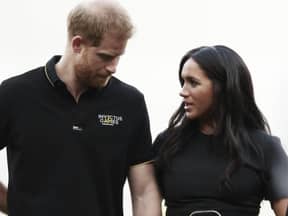 Prinz Harry sieht zu Boden, Herzogin Meghan sieht in fordernd an