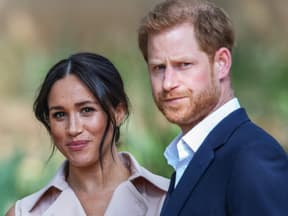 Herzogin Meghan schmunzelt und Prinz Harry guckt ernst