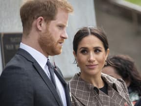 Prinz Harry schaut ernst, Ehefrau Meghan sieht ihn fragend an