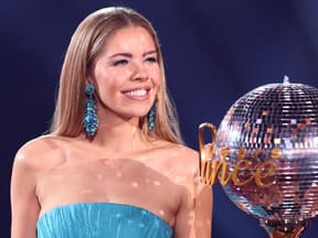 Victoria Swarovski lächelt und neben ihr steht der Let's Dance Pokal.