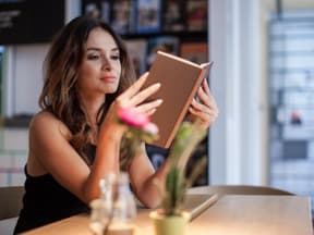 Frau liest ein Buch in einem Café