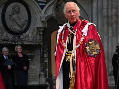 Prinz Charles in rotem Mantel schaut ernst 