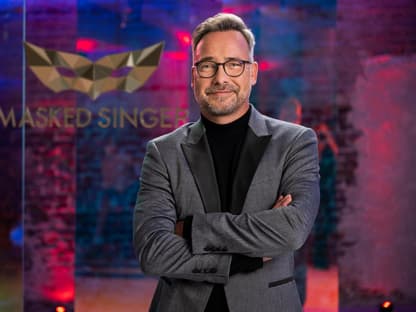 Matthias Opdenhövel vor dem "The Masked Singer"-Logo