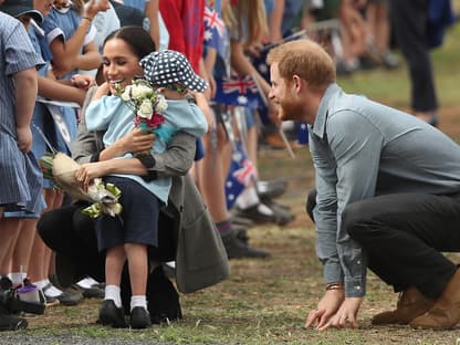 Harry und Meghan 2018 auf ihrer Australien-Reise - Meghan umarmt einen kleinen Jungen