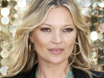 Kate Moss vor einem goldenen Hintergrund.