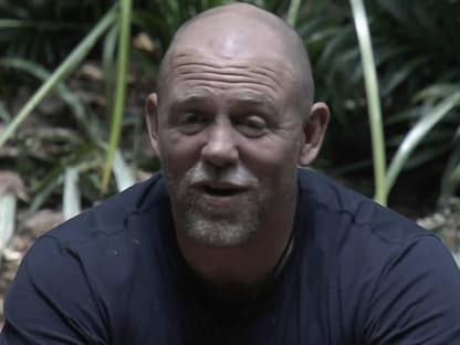 Mike Tindall sitzt vor einem Busch