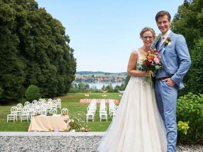 Sturm der Liebe Josie und Paul stehen in Brautkleid und Anzug vor einer Festwiese