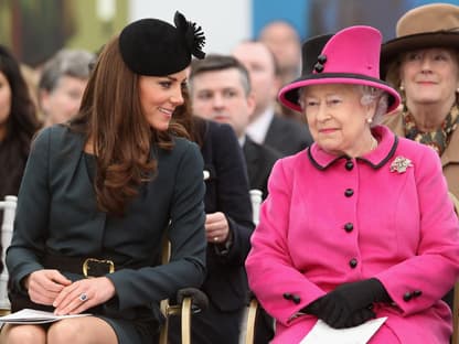 Prinzessin Kate und Queen Elizabeth II. sitzen nebeneinander und lachen.