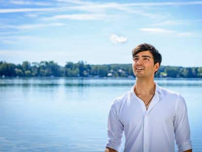 Sturm der Liebe, Leander schaut nach oben, im Hintergrund ein See