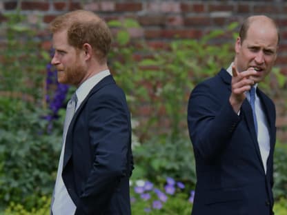 Prinz Harry und Prinz William stehen mit dem Rücken zueinander.