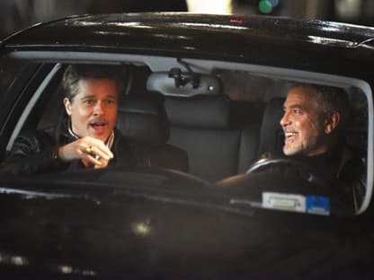 George Clooney und Brad Pitt lachen im Auto am Filmset von Wolves