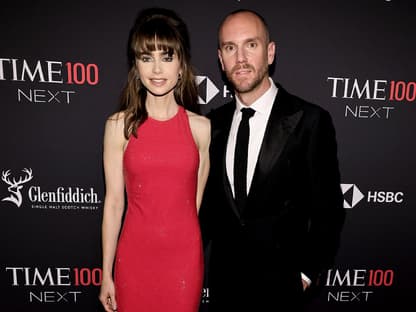 Lily Collins und Charlie McDowell posieren vor einer dunklen Wand