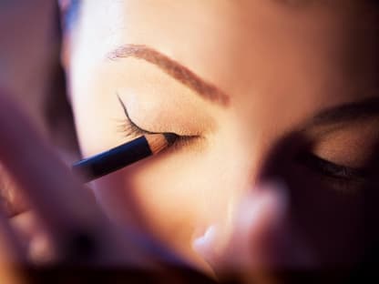 Frau schminkt sich mit Eyeliner 