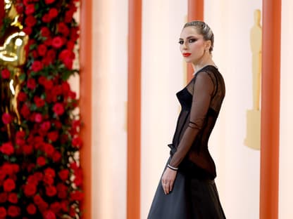 Lady Gaga steht seitlich auf dem Oscars-Teppich und guckt ernst