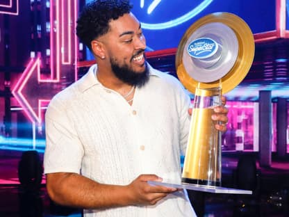 Sem Eisinger lacht und schaut den DSDS-Pokal an