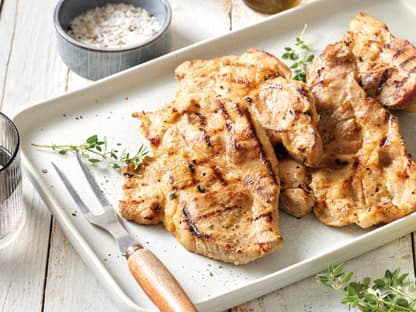 Gegrillte Nackensteaks in Bier-Marinade auf einem Teller