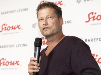 Till Schweiger guckt ernst mit Mikro in der Hand