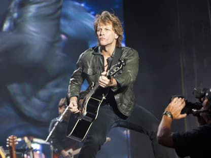 Jon Bon Jovi spielt Gitarre auf der Bühne