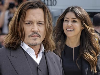 Johnny Depp und Camille Vasquez lächeln nebeneinander