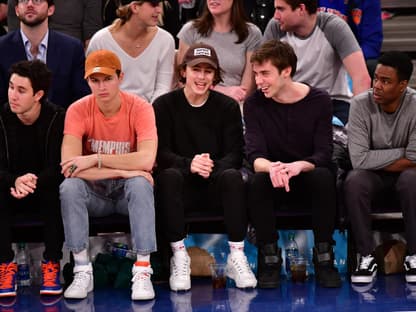 Timothée Chalamet sitzt mit Freunden am Rand eines Basketballspiels