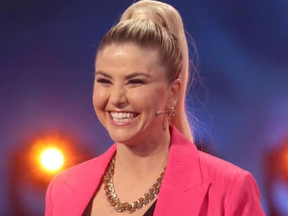 Beatrice Egli lächelt im pinken Anzug