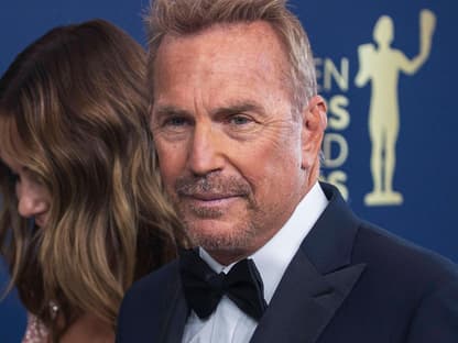 Kevin Costner guckt ernst, lächelt leicht