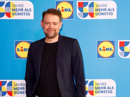 Max Giermann lächelt bei Lidl-Event im Anzug