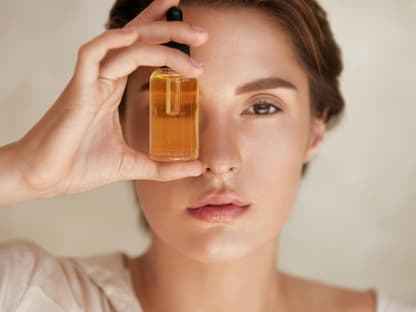 Frau hält Anti-Aging-Serum vors Gesicht